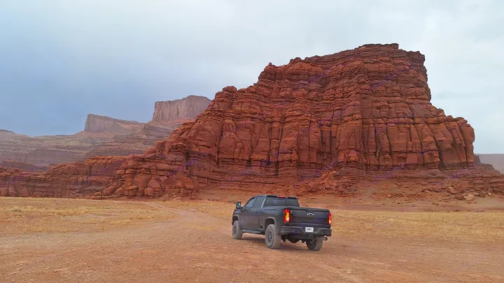 A black pickup truck explores a majestic red rock desert. For epic road trips like this, consider an rv rental adventure!. Chevrolet Silverado 2500HD ZR2 Bison 2025