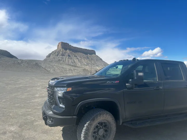 Rugged black Chevrolet HD ZR2 truck on dirt road with majestic mesa. Perfect for exploring areas with an rv rental.. Chevrolet Silverado 2500HD ZR2 Bison 2025