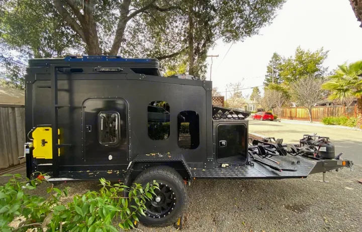 This rugged black off-road adventure trailer, ideal for your next RV rental, features a rear gear deck and storage.. ITWO custom Pixtech Bearlander 20 2024