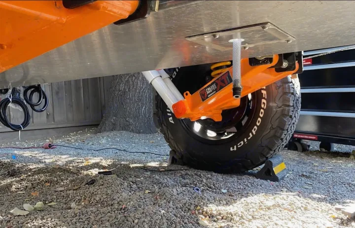 RV rental underside with robust Cruise Master XT suspension, BFGoodrich tire, and visible drain hose.. ITWO custom Pixtech Bearlander 20 2024