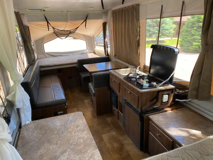 Inside this modern RV rental: a compact kitchen, comfortable dinette, and cozy beds for your next adventure.. Forest River Rockwood ESP 2018