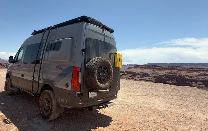 A gray adventure van, a fantastic rv rental, parked overlooking vast red rock canyon views under a clear sky.. Storyteller Overland Storyteller Overland Class B 2023