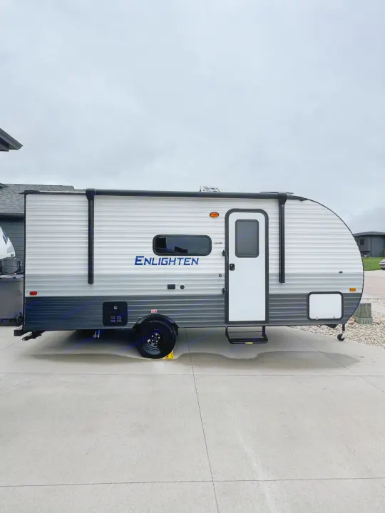Grey & white 'ENLIGHTEN' travel trailer, a great rv rental choice, parked on concrete under an overcast sky.. Gulf Stream Coach Enlighten 17bh 2025
