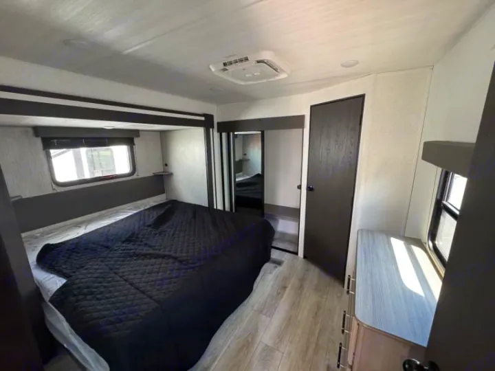 Step into this inviting RV rental bedroom with a comfy bed, window, mirrored closet, and dresser.. evergreen sun valley 2015