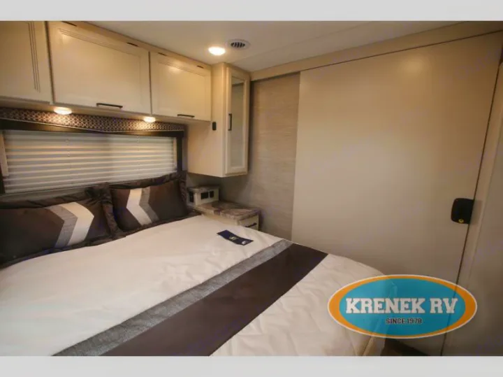 Comfortable RV rental bedroom interior, featuring a spacious bed, overhead cabinets, and a compact design.. Thor Chateau 2022