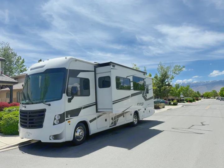 White FR3 RV rental parked on a sunny street, ready for adventure with distant snow-capped mountains.. FR3 FR3 Motorhome 2023