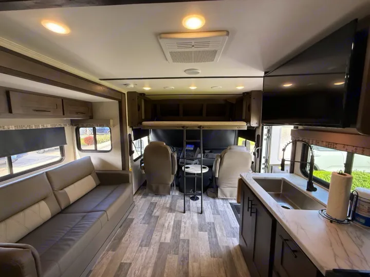 Experience comfort in this modern rv rental interior. Features a spacious living area, kitchen, driver's cabin, and overhead bunk.. FR3 FR3 Motorhome 2023