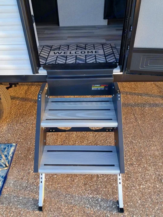 RV rental entrance: Three sturdy steps provide access to a 'WELCOME' mat visible inside the camper.. Jayco Jay Flight SLX 210 QB 2025