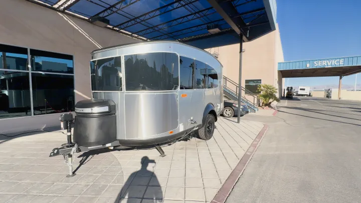 A shiny Airstream travel trailer at an RV service center, ideal for your next RV rental adventure.. Airstream Basecamp 2024