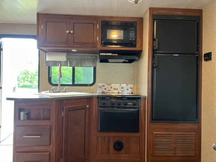 Explore this functional RV rental kitchen! Features include a microwave, Dometic fridge, Suburban stove, and a compact sink.. Heartland RVs Mallard 2018