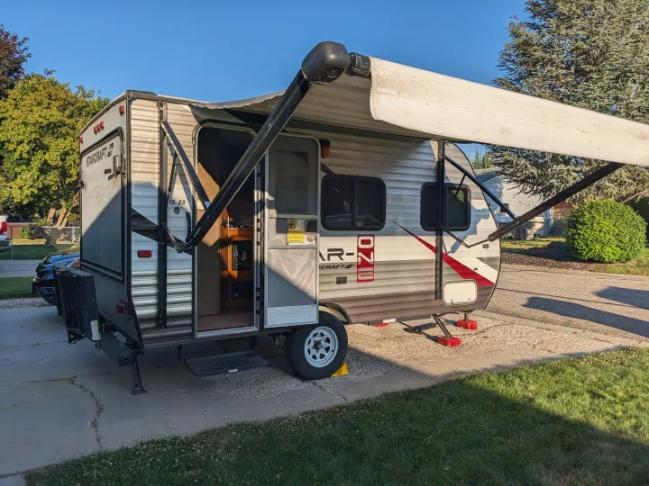 A Starcraft travel trailer is parked with its awning extended and door open. This RV rental is ready for your next adventure.. Starcraft AR-One 2015