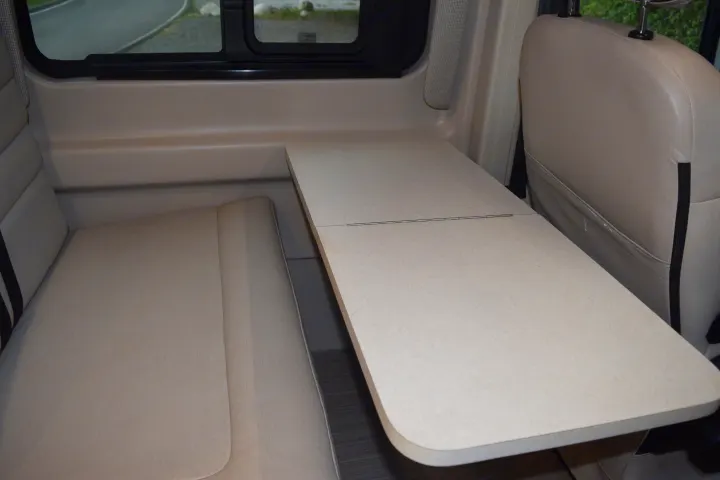 RV rental interior: A light-colored dinette with a folding table and comfortable seating, perfect for travel.. Thor Sequnce 2023