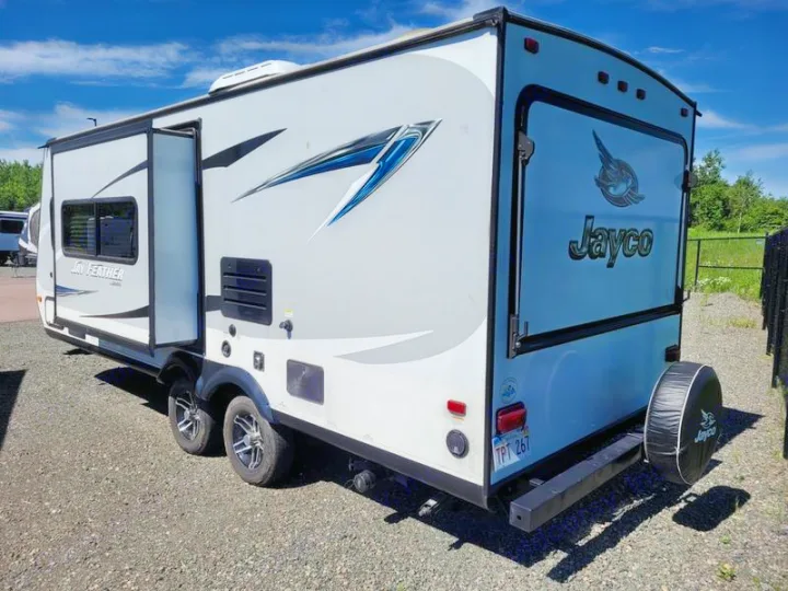 Grey Jayco travel trailer RV with an open slide-out, parked on gravel. Ideal for your next rv rental adventure.. Jayco Jay Feather 2021