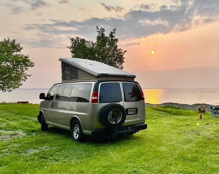 Tranquil sunset by the water with an RV rental, a cozy fire, and a dog. Ideal for camping & travel.. Chevrolet chevrolet express 2500 New West high 2004