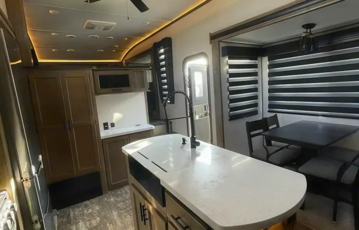 Modern RV rental interior: spacious kitchen island, dining area, and stylish lighting.. Forest River Sabre 2021