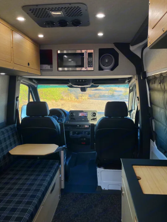 Modern RV rental interior: kitchen, dining, seating & front cabin for travelers.. Mercedes Sprinter 2023