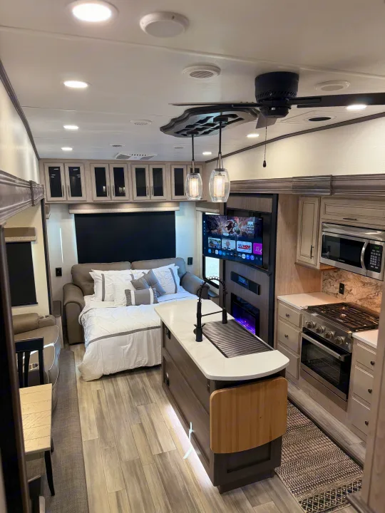 Luxury RV rental interior featuring a spacious living area, modern kitchen, and comfortable pull-out bed.. Forest River 3370RLS 2024