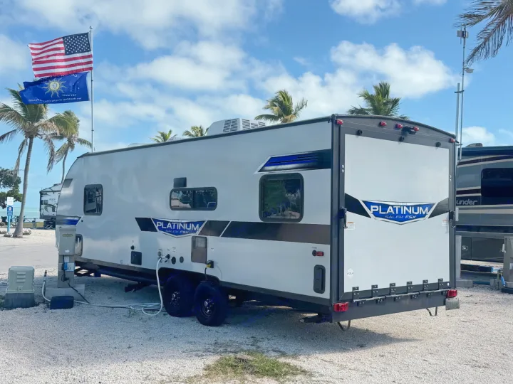 This Platinum Salem FSX travel trailer RV rental is set up at a scenic park with utility hookups under a blue sky.. Forest River Salem 2022