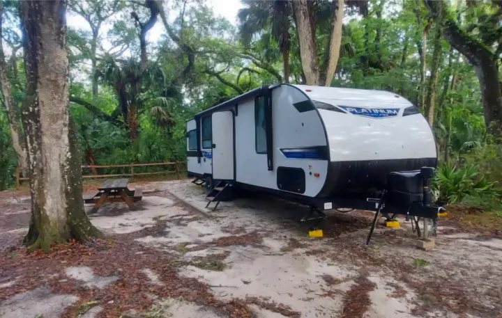 This RV rental is perfectly set up at a shaded, sandy campsite with a picnic table & lush trees surrounding it.. Forest River Salem 2022