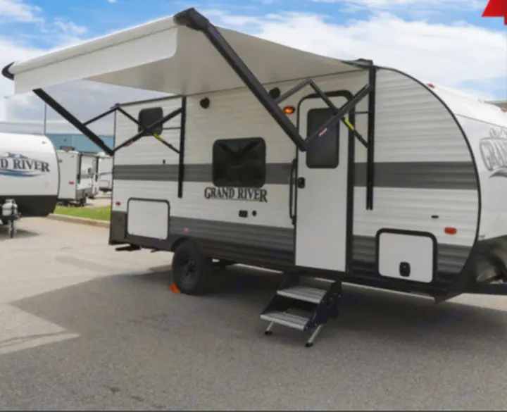 White Grand River travel trailer RV rental, with a deployed awning and extended steps. Ideal for your next outdoor adventure.. Gulf Stream Grand River 2024