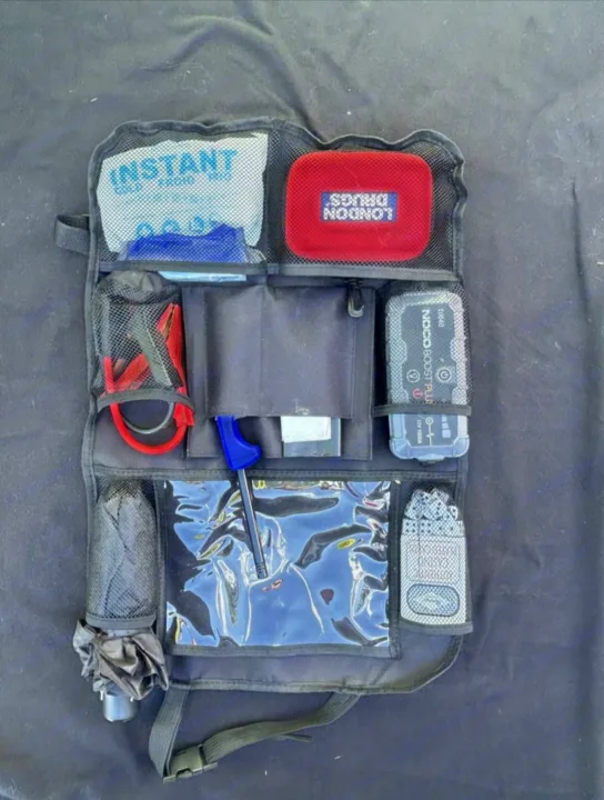 Organized RV rental gear: a car seat organizer with a NOCO jump starter, first aid kit, umbrella, and emergency tools.. Dodge Caravan 2006