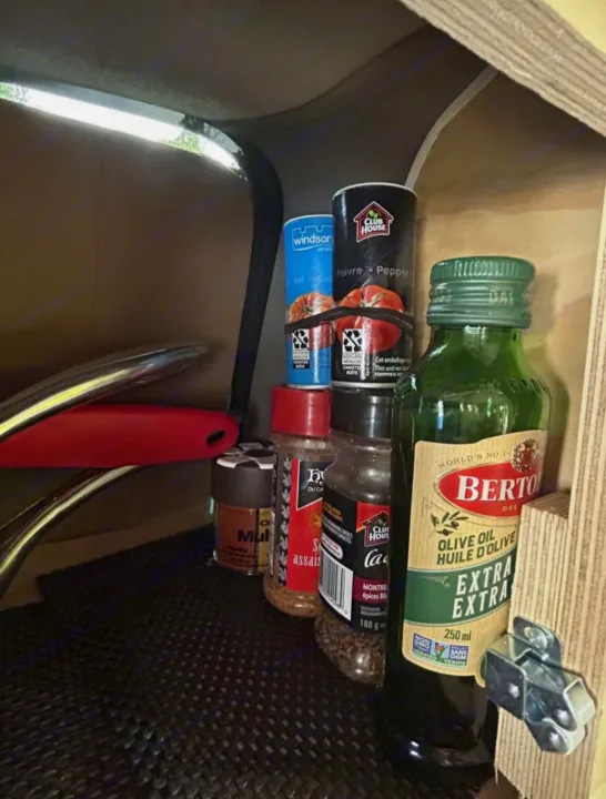 Compact RV rental kitchen storage: salt, pepper, spices, and olive oil securely organized for cooking on the go.. Dodge Caravan 2006