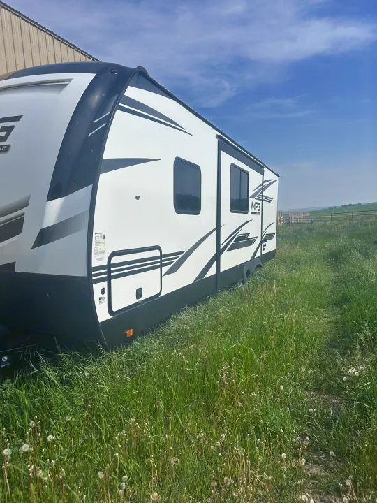 White & black travel trailer, perfect for RV rental, sitting in a sunny grassy field.. MPG Cruiser RV ultra light 2500 2021