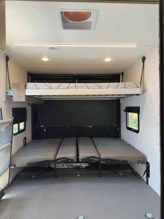 RV rental: Bright, versatile RV interior showcasing adjustable bunk beds and lower convertible seating for flexible use.. Coachmen Adrenaline 2025
