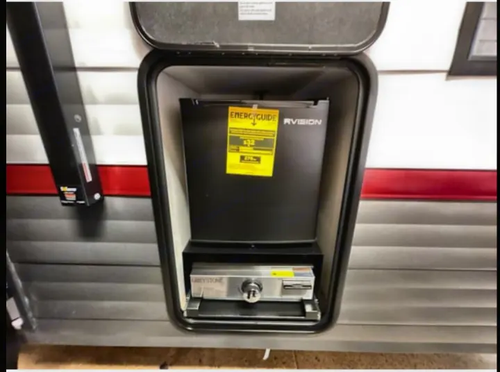 RV rental: Outdoor kitchen featuring an RVISION mini-fridge and Greystone grill for convenient outdoor cooking.. Forest River Campsite Reserve 26CJ 2025