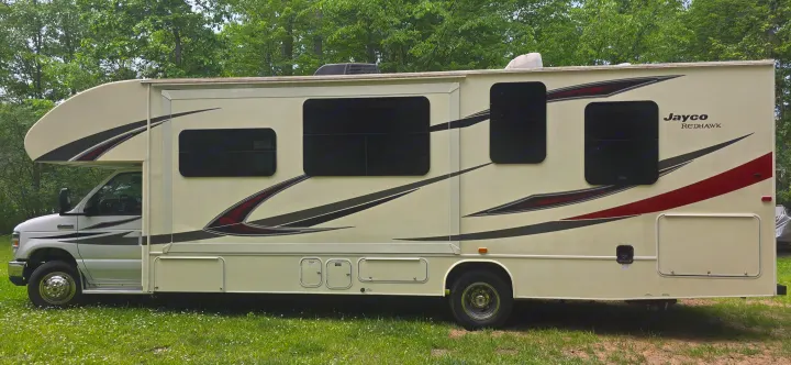 Cream Jayco Redhawk Class C RV, side view on grass. Great for an rv rental, camping, or road trip.. Jayco Redhawk 2017