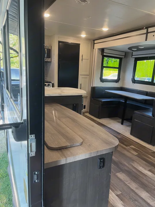 RV rental: Interior view of modern kitchen with island, refrigerator, and a U-shaped dinette.. Crossroads RV Cruiser Aire 2022