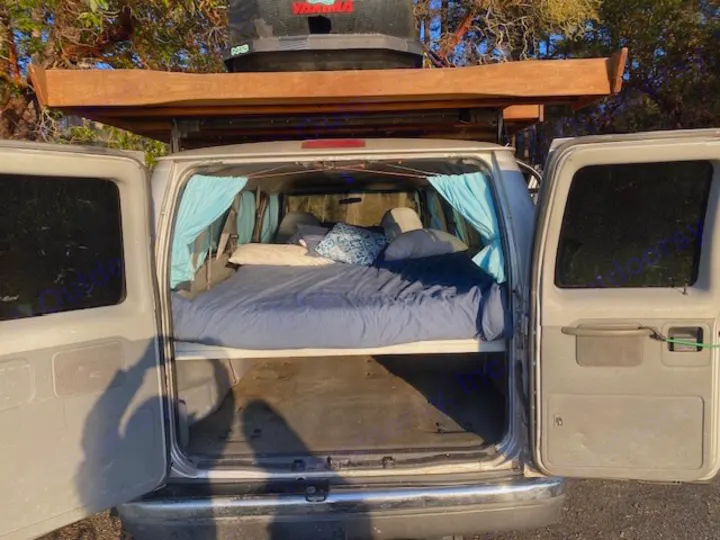 Explore in comfort with this RV rental van! Features a built-in bed & roof cargo, ideal for camping and travel.. Ford E350 Box Van 2003