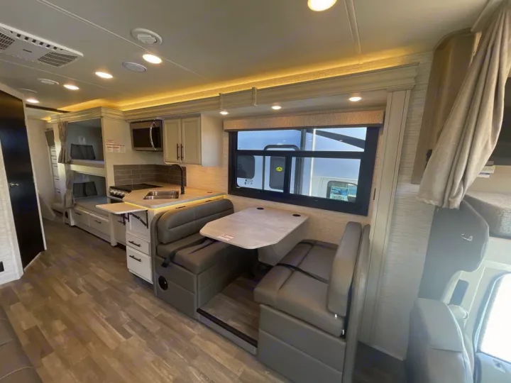 Spacious RV rental interior featuring a modern kitchen, comfortable dinette, and bunk beds for family travel.. Jayco Greyhawk 2026