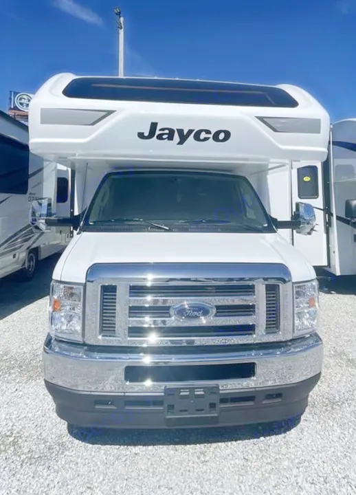 Front view of a white Jayco RV built on a Ford chassis, parked on a gravel lot. Ideal for your next rv rental adventure.. Jayco Greyhawk 2026