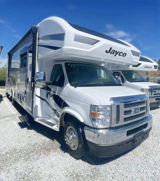 White Jayco Greyhawk Class C RV rental, a spacious motorhome, parked on a gravel lot under a clear sky.. Jayco Greyhawk 2026