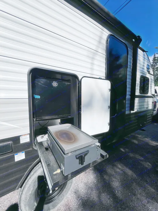 RV rental with convenient outdoor cooking station featuring a pull-out griddle and mini-fridge, perfect for camping.. Clipper 4K 2023