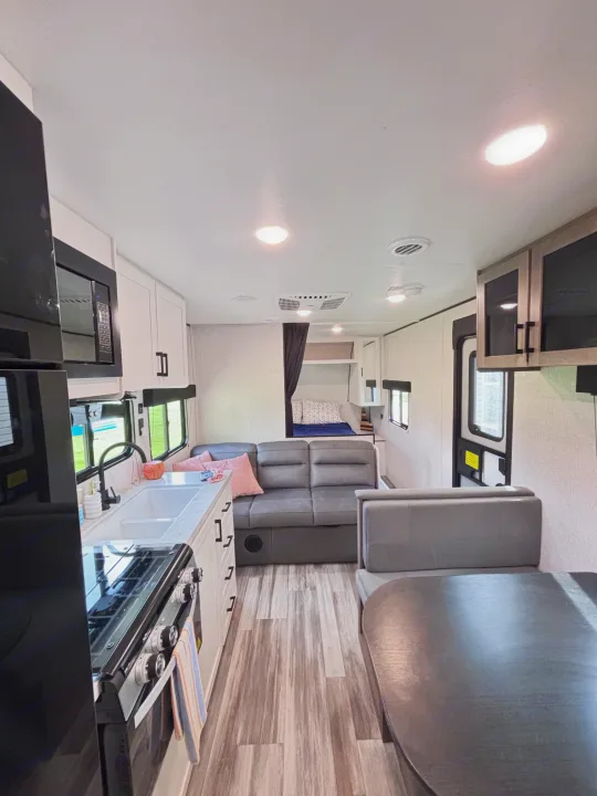 Bright RV rental interior: modern kitchen, living sofa, dining area, and bedroom. Perfect for your travels!. Jayco Jay Flight slx 260 bhw 2025
