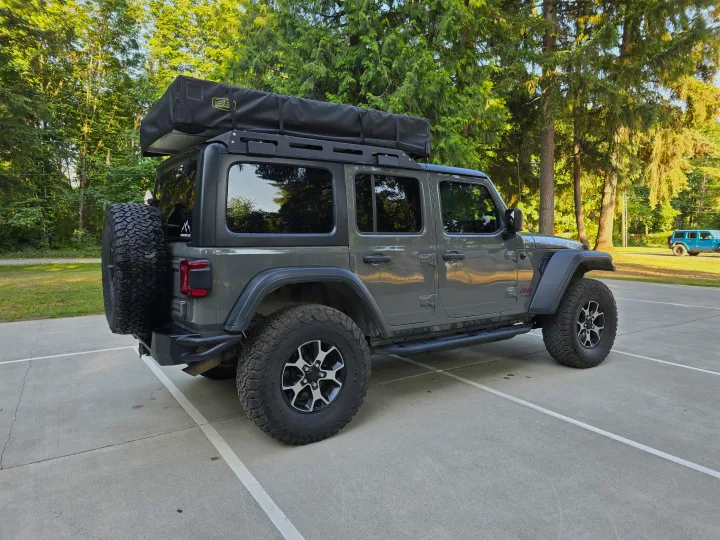 Grey Jeep Wrangler with rooftop tent—a versatile RV rental alternative for off-road camping adventures.. Jeep Wrangler Unlimited Rubicon 2019