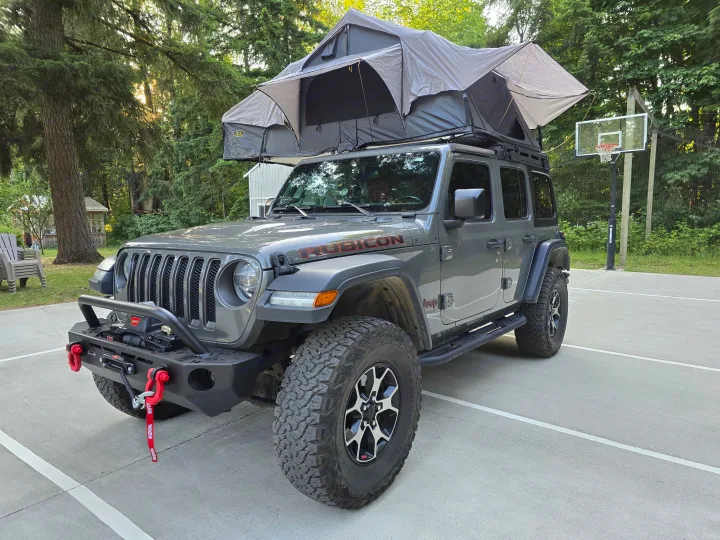 Gray Jeep Wrangler with a deployed rooftop tent on a court. Perfect as an rv rental alternative for camping adventures.. Jeep Wrangler Unlimited Rubicon 2019