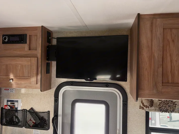 Inside this RV rental: Wall-mounted TV, built-in stereo, wood cabinets, and door with window. A cozy, equipped travel space.. Forester Forester Motorhome 2020