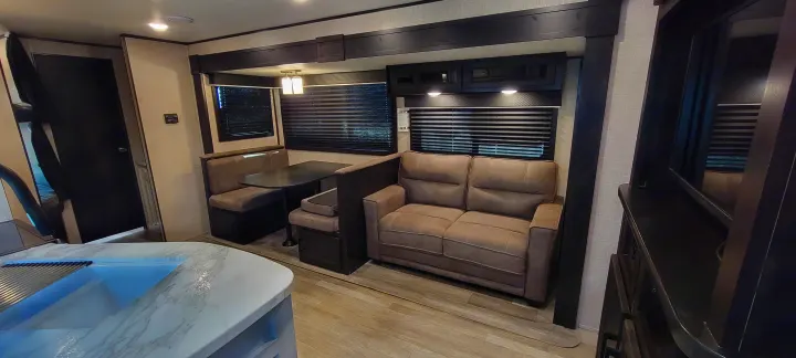 Cozy RV rental interior with a dinette, sofa, kitchen counter, and bunk access, perfect for family trips.. Jayco Jayco Rocky Mountain 2022