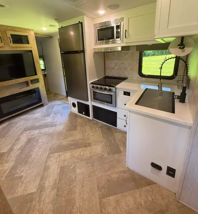 Spacious RV rental with a sleek kitchen (fridge, stove, microwave, sink) and living area with TV & fireplace.. Palomino SolAire 320 TSBH 2022