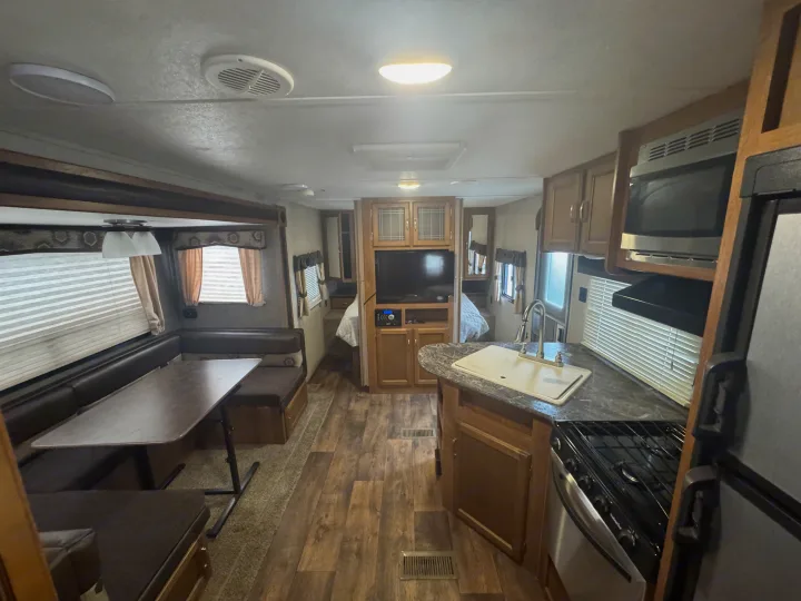 Explore this RV rental's spacious interior: full kitchen, comfortable dinette, and private bedroom setup.. Keystone RV Springdale 2018