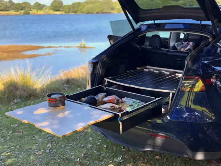 Tesla Model Y car camping setup by lake. Pull-out kitchen & bed platform. Great for road trips, like an RV rental experience!. Telstar Model Y 2023