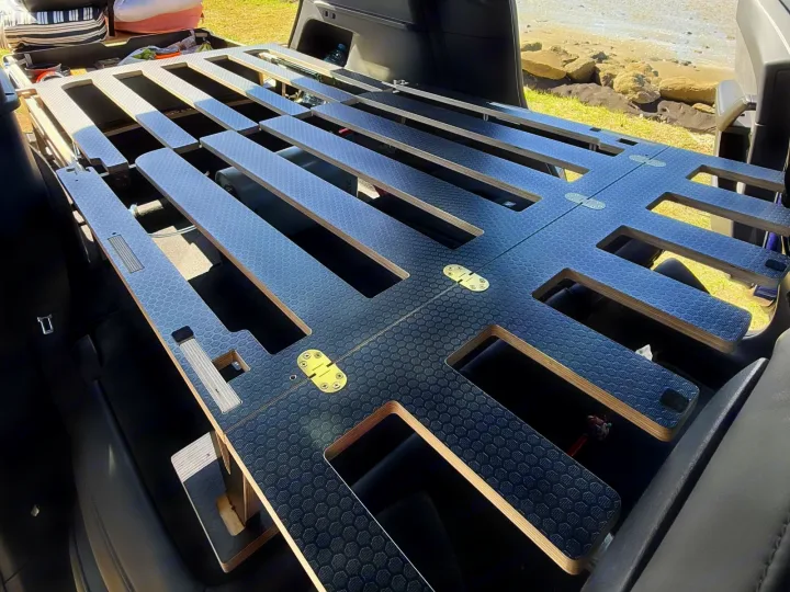An RV rental's clever modular sleeping platform for car camping. Features a textured surface and open storage below.. Telstar Model Y 2023