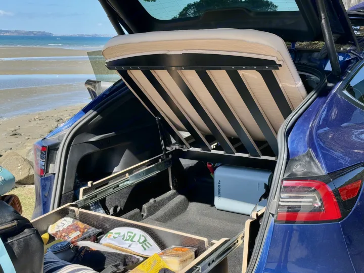 Blue Tesla trunk transformed for car camping: a custom bed, storage drawers, and Dometic cooler. Great RV rental alternative at the beach.. Telstar Model Y 2023