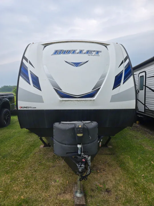 Front of a white "Bullet by Keystone" travel trailer, with blue and grey decals, ideal for your next RV rental adventure.. Keystone RV Bullet Ultra Lite 2018