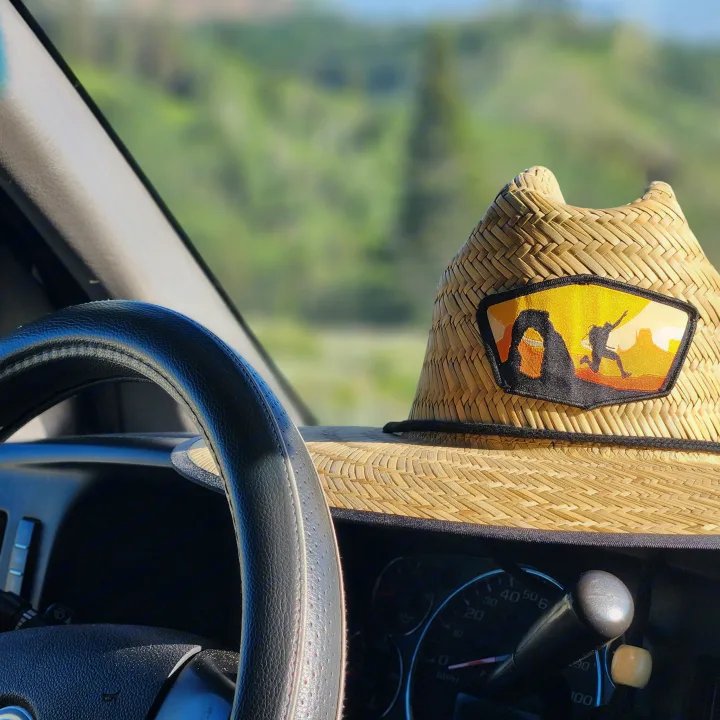 RV rental trip! Straw hat with desert arch patch on dashboard. Green landscape beyond windshield.. Chevrolet Express 1500 AWD 2014