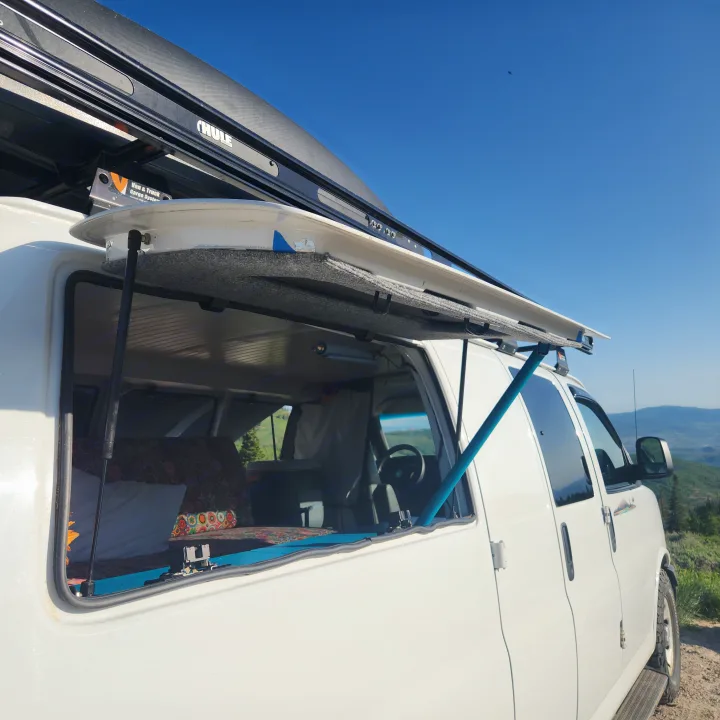 Experience van life with an RV rental! White conversion van with open window overlooking scenic mountains. Perfect for adventure.. Chevrolet Express 1500 AWD 2014