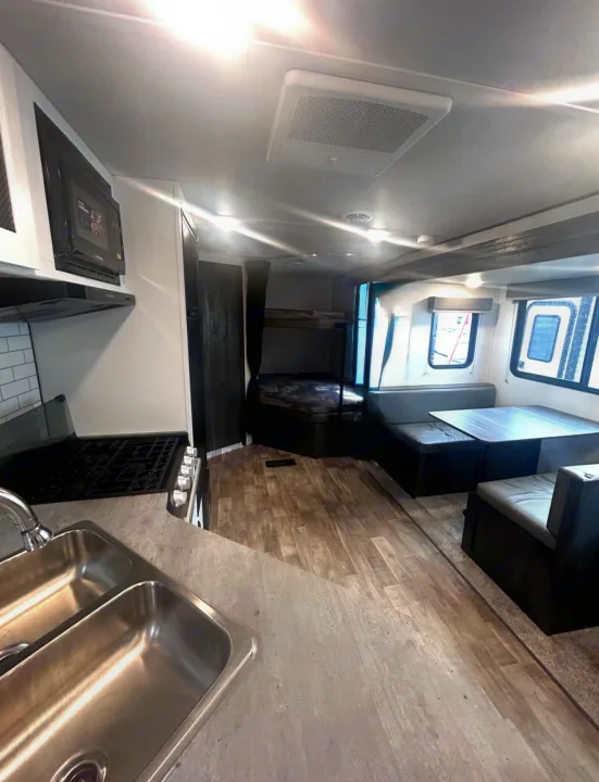 Spacious RV rental interior with kitchen, dinette, and bunk beds, perfect for comfortable travel.. Keystone RV Hideout 2023